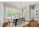 Bright dining room featuring a modern chandelier and large windows overlooking the lush backyard at 7116 Dumfries Ln, Chapel Hill, NC 27514