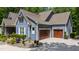 Blue two-story home with a two-car garage and well-manicured landscaping at 7116 Dumfries Ln, Chapel Hill, NC 27514