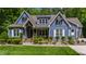 Charming blue two-story home with lush landscaping, covered porch, and stone accents at 7116 Dumfries Ln, Chapel Hill, NC 27514