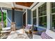 Cozy front porch with stone accents, wood ceiling, and comfortable seating creates an inviting entrance at 7116 Dumfries Ln, Chapel Hill, NC 27514