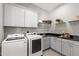 Well-equipped laundry room with modern washer, dryer, cabinets, and a sink at 7116 Dumfries Ln, Chapel Hill, NC 27514