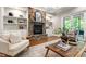 Cozy living room featuring a stone fireplace, built-in shelving, and plush seating at 7116 Dumfries Ln, Chapel Hill, NC 27514
