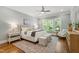 Bright main bedroom featuring a large window, ceiling fan, and sitting area at 7116 Dumfries Ln, Chapel Hill, NC 27514