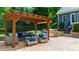 A stylish patio area features a pergola, comfortable seating, and a built-in grill for outdoor living at 7116 Dumfries Ln, Chapel Hill, NC 27514