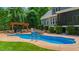 Inviting pool area with a hot tub, a built-in grill, and a pergola-covered seating area for outdoor enjoyment at 7116 Dumfries Ln, Chapel Hill, NC 27514