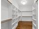 Spacious walk-in closet featuring custom shelving and hardwood floors at 7116 Dumfries Ln, Chapel Hill, NC 27514
