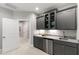 Stylish wet bar area with gray cabinets, granite countertops, and stainless-steel appliances at 7116 Dumfries Ln, Chapel Hill, NC 27514