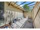 An outdoor patio area with a privacy fence and simple seating arrangement with natural light filtering through overhead trellis at 75 Stone Hill Ct, Durham, NC 27704