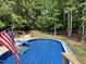 Inviting backyard featuring a pristine pool, perfect for relaxation and outdoor entertainment, framed by lush greenery at 7824 Hemlock Ct, Raleigh, NC 27615