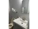 Neat bathroom featuring a gray vanity, an octagonal mirror, and modern fixtures with neutral paint at 7824 Hemlock Ct, Raleigh, NC 27615