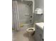 Clean bathroom with a shower/tub combo, a gray vanity, and a toilet with neutral tile flooring at 7824 Hemlock Ct, Raleigh, NC 27615