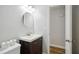 Bathroom featuring a dark wood vanity with a white sink and modern round mirror at 7824 Hemlock Ct, Raleigh, NC 27615