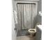 Bathroom featuring neutral tile, shower-tub combo, white vanity, and classic fixtures at 7824 Hemlock Ct, Raleigh, NC 27615