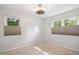Bedroom with neutral carpet, ceiling fan, and two large windows with privacy shades at 7824 Hemlock Ct, Raleigh, NC 27615