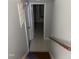 Hallway leading to stairs with tile flooring and modern wood handrail in a home interior at 7824 Hemlock Ct, Raleigh, NC 27615