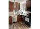 Well-equipped kitchen with modern appliances, wood cabinets, a stainless steel dishwasher, and stone countertops at 7824 Hemlock Ct, Raleigh, NC 27615