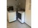 Laundry room features modern washer and dryer, water heater, storage cabinets, and a tiled floor at 7824 Hemlock Ct, Raleigh, NC 27615