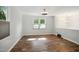 Bright living room featuring wood floors, neutral paint, modern lighting, and large windows at 7824 Hemlock Ct, Raleigh, NC 27615