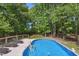Backyard pool area featuring a deck with lounge chairs and a wooded backdrop at 7824 Hemlock Ct, Raleigh, NC 27615