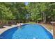 Inviting backyard pool with sun deck and surrounded by mature trees providing shade and privacy at 7824 Hemlock Ct, Raleigh, NC 27615