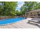 Backyard pool with surrounding deck and lounge chairs next to house at 7824 Hemlock Ct, Raleigh, NC 27615