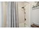Shower with gray and white shower curtain and updated shower head and fixtures at 7824 Hemlock Ct, Raleigh, NC 27615