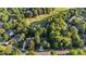 Aerial view of property showcasing its wooded setting close to a golf course and mature trees at 905 Neuse Ridge Dr, Clayton, NC 27527