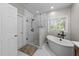 Bathroom with a walk-in shower, soaking tub under window and white hexagon tile floor at 905 Neuse Ridge Dr, Clayton, NC 27527