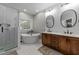 Modern bathroom featuring a soaking tub, walk-in shower, double vanity and wood cabinets at 905 Neuse Ridge Dr, Clayton, NC 27527