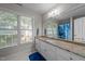 Bright bathroom with granite countertop, vanity, large mirror, and window with natural light at 905 Neuse Ridge Dr, Clayton, NC 27527