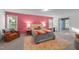 Charming bedroom with pink accent wall, plush armchair, and a cozy rug, creating a warm atmosphere at 905 Neuse Ridge Dr, Clayton, NC 27527