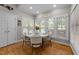 Dining area with wood floors, white table with four chairs, and large windows at 905 Neuse Ridge Dr, Clayton, NC 27527