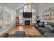 Living room with wood floors, fireplace, large windows, modern gray sectional, and high ceiling at 905 Neuse Ridge Dr, Clayton, NC 27527