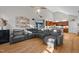 Spacious living room features modern gray sectional, wood floors, and open access to kitchen and stairs at 905 Neuse Ridge Dr, Clayton, NC 27527