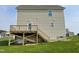 Exterior view of the home's backyard with a wooden deck and stairs leading to the lawn at 94 Starry Sky Dr, Benson, NC 27504