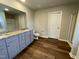 Well-lit bathroom featuring double sinks, granite countertops, and wood-look flooring at 94 Starry Sky Dr, Benson, NC 27504