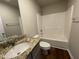 Functional bathroom with granite countertops, a sink, a toilet, and a bathtub/shower combo at 94 Starry Sky Dr, Benson, NC 27504