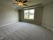 Large main bedroom with neutral carpet, tray ceiling, and a window at 94 Starry Sky Dr, Benson, NC 27504