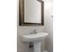 Modern pedestal sink with framed mirror, adding a stylish touch to the bathroom at 1 Edgebrook Cir, Durham, NC 27703