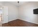 Bedroom featuring wood laminate flooring, door, and television at 1 Edgebrook Cir, Durham, NC 27703