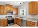 Well-equipped kitchen with stainless steel appliances, wood cabinets, and a functional layout at 1 Edgebrook Cir, Durham, NC 27703
