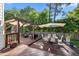 Spacious backyard showcasing a wooden deck with outdoor seating, sunshade, and lush greenery at 1028 Bellenden Dr, Durham, NC 27713