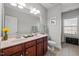 Bright bathroom with double vanity, cherry wood cabinets, framed mirror, and a separate toilet area at 1028 Bellenden Dr, Durham, NC 27713