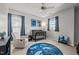 Bedroom with crib, rocking chair, and space-themed rug under ceiling fan and ample natural light at 1028 Bellenden Dr, Durham, NC 27713