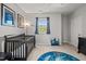 Bedroom featuring a dark wood crib, comfortable seating, and a playful space-themed rug at 1028 Bellenden Dr, Durham, NC 27713