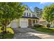 Inviting two-story home featuring a two-car garage, a covered porch and manicured landscaping at 1028 Bellenden Dr, Durham, NC 27713