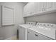 Clean and functional laundry room with modern washer and dryer units and ample storage cabinets at 1028 Bellenden Dr, Durham, NC 27713