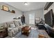 Cozy living room area with plush couch, television, and shelves, perfect for relaxing and entertaining at 1028 Bellenden Dr, Durham, NC 27713