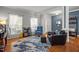 Cozy living room boasts wood floors, two large windows, a stylish blue accent wall and comfy furniture at 1028 Bellenden Dr, Durham, NC 27713
