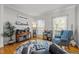 Sun-filled living room with gleaming hardwood floors, large windows, and comfortable blue seating at 1028 Bellenden Dr, Durham, NC 27713